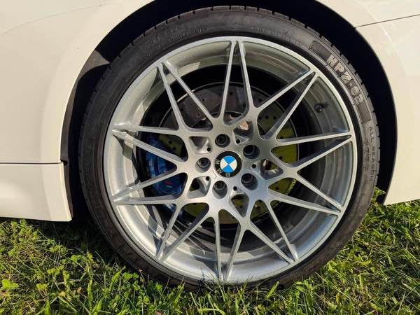 Silver powder coated BMW wheel on a white convertible