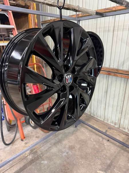 Buick wheel powder coated black metallic, hanging on the rack