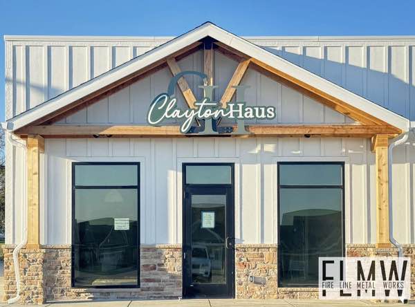 3 layer plasma cut and powder coated building sign installed over the entrance of ClaytonHaus