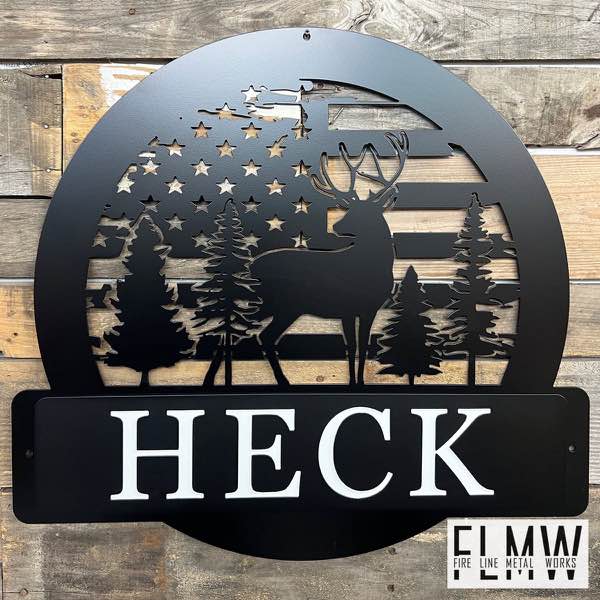 Round black plasma cut family name sign with an American flag, deer, and pine trees