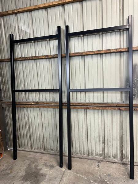 Two black steel outdoor electrical panel mounting brackets